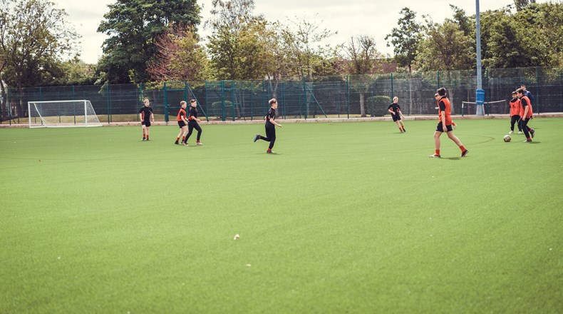 Students playing football on the schools astro pitch
