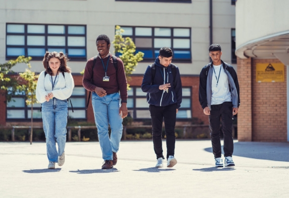 Group of Sixth Form students walking away from the academy building